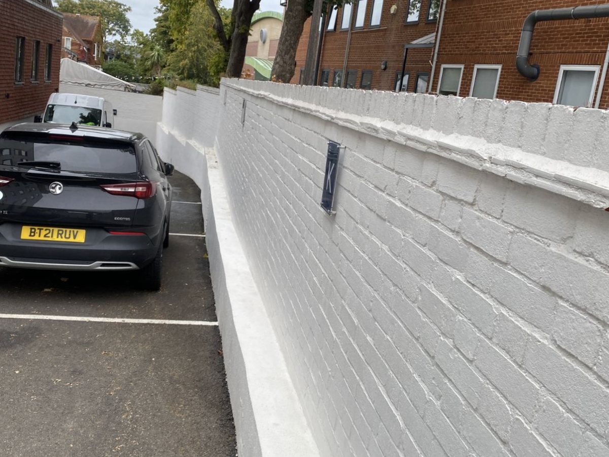 Boundary wall after treatment, restored to original white finish